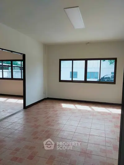 Spacious unfurnished room with large windows and tiled flooring, perfect for customization.