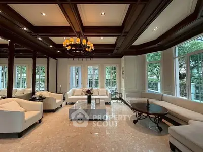 Luxurious living room with elegant furniture and large windows offering garden views.