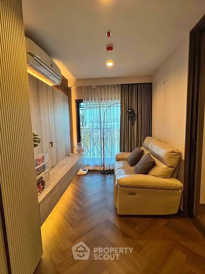 Cozy living room with modern decor and large window offering natural light.
