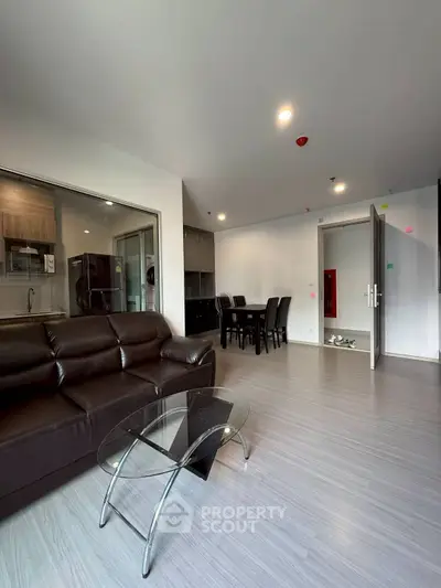 Modern living room with sleek furniture and open kitchen layout in a stylish apartment.