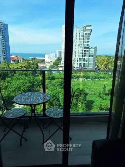 Stunning balcony view with lush greenery and ocean backdrop, perfect for relaxation.