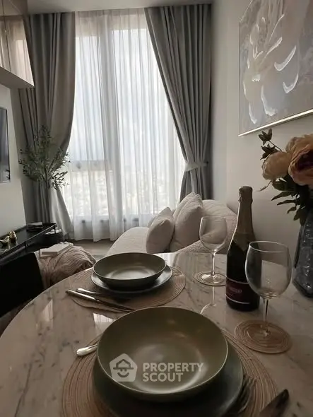 Elegant living room with modern decor and dining setup, featuring large window with city view.