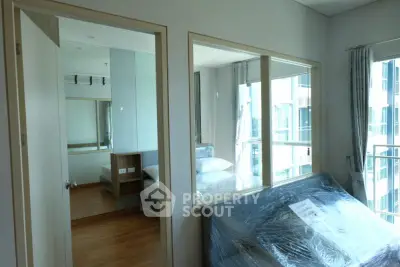 Modern bedroom with large windows and wooden flooring in a high-rise apartment