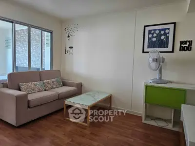 Cozy living room with modern decor and natural light, featuring a comfortable sofa and stylish coffee table.