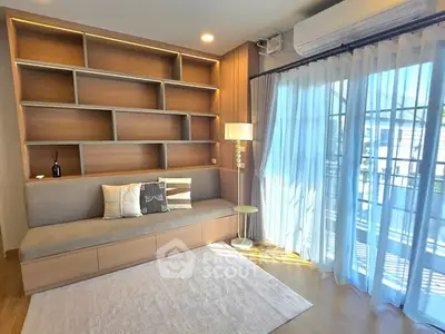 Bright living room with built-in shelves and large window for natural light.
