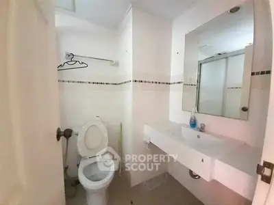 Compact bathroom with modern fixtures and a clean design, featuring a toilet and sink.