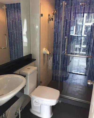 Modern bathroom with sleek shower and stylish blue tile accents