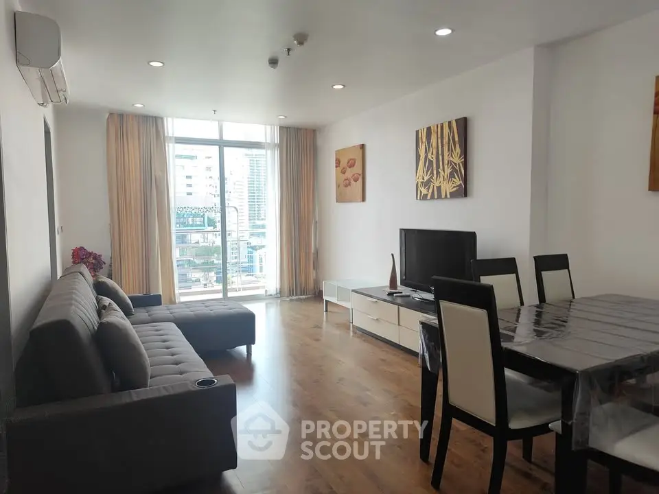 Spacious modern living room with large window and city view, featuring stylish furniture and elegant decor.