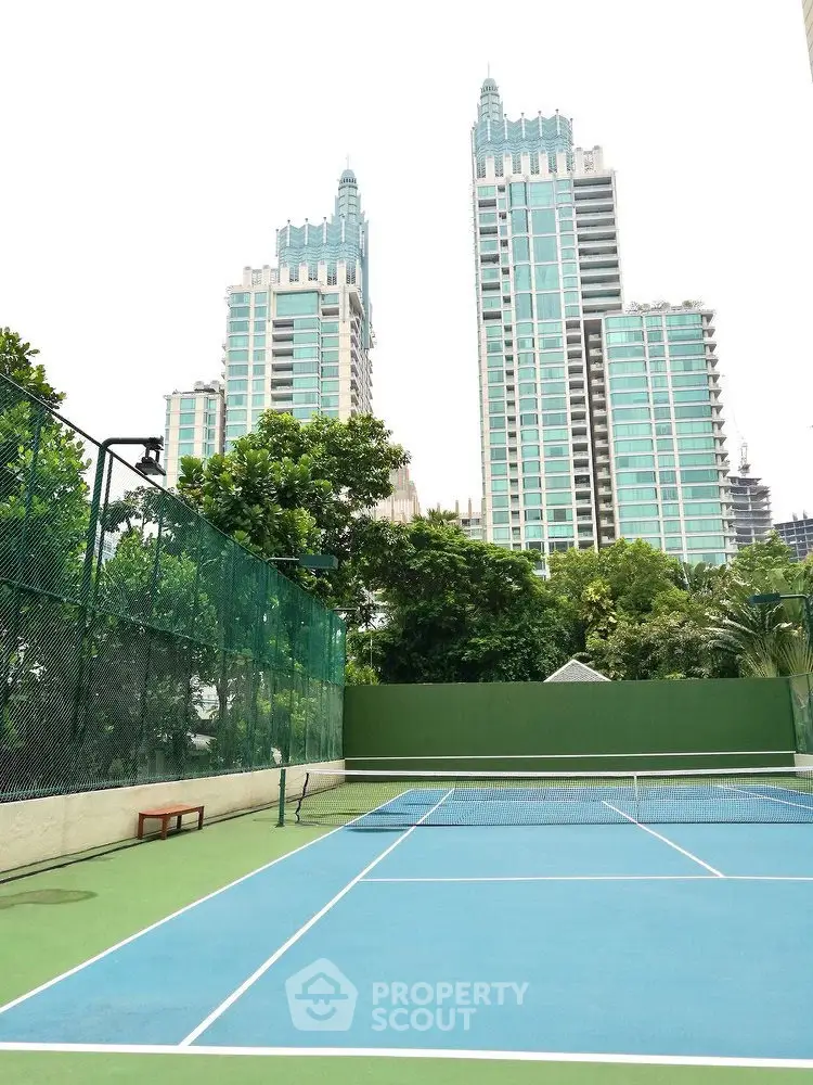 Luxurious residential towers with tennis court and lush greenery
