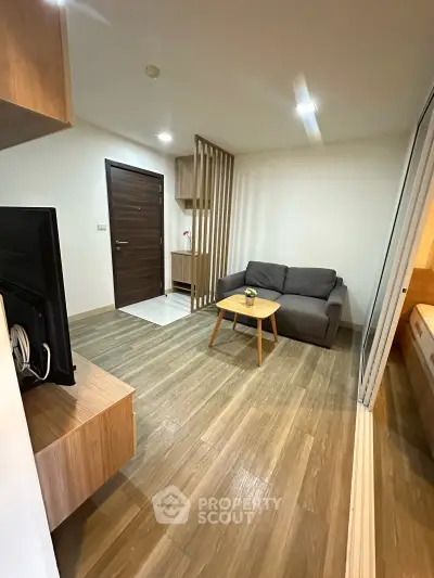 Modern living room with wooden flooring and cozy sofa in a stylish apartment.