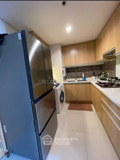 Modern kitchen with sleek appliances and stylish cabinetry in a cozy apartment.
