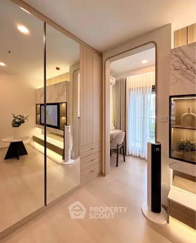 Modern living room with elegant decor and natural light, featuring a sleek TV unit and stylish furnishings.