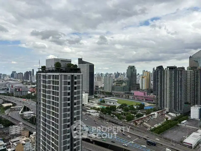 Stunning cityscape view from a high-rise building showcasing urban skyline and highways.