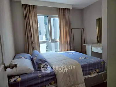 Cozy bedroom with modern decor and ample natural light from large window.