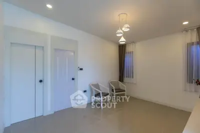 Minimalist interior with modern lighting and seating area in a spacious room.