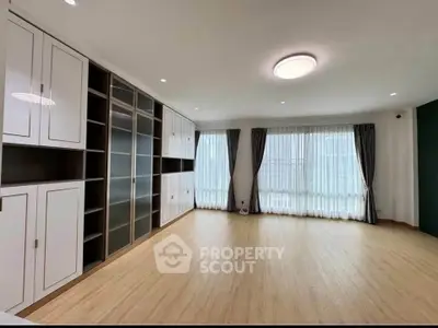 Spacious living room with built-in shelves and large windows for natural light.