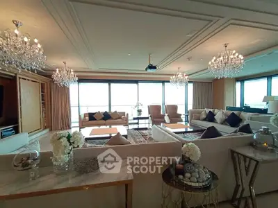 Luxurious living room with elegant chandeliers and panoramic windows offering stunning views.