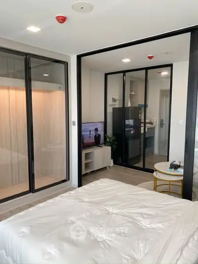 Modern bedroom with glass sliding doors and built-in wardrobe