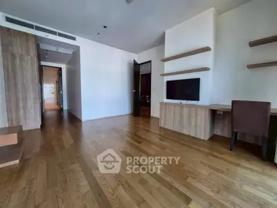 Spacious modern living room with wooden flooring and built-in shelves, perfect for stylish urban living.