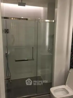 Modern bathroom with glass shower enclosure and sleek fixtures.