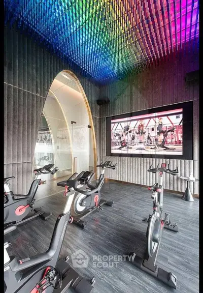 Luxurious modern gym with vibrant ceiling lighting and state-of-the-art exercise bikes.