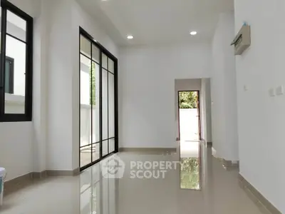 Spacious modern interior with sleek design and glossy floors, featuring large windows for natural light.