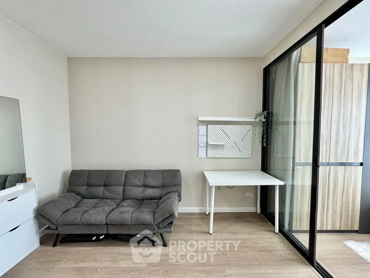 Modern living room with sleek sofa and glass partition in stylish apartment.