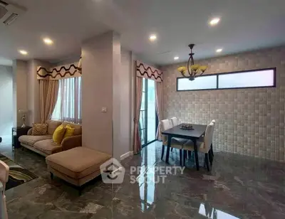 Elegant living and dining area with modern decor and ample natural light.