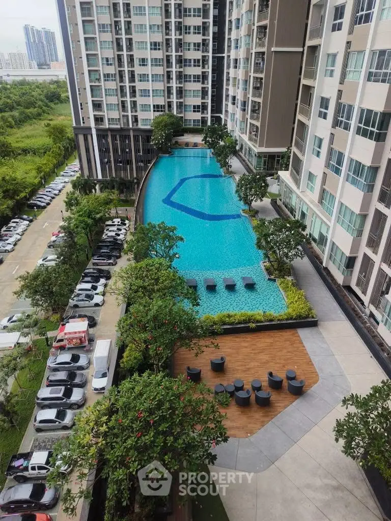 Luxurious high-rise apartment with stunning pool and lush greenery view.