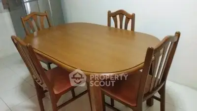 Elegant wooden dining table set with four chairs in a cozy dining area.