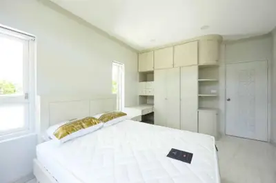 Bright and spacious bedroom with modern built-in storage and large windows.