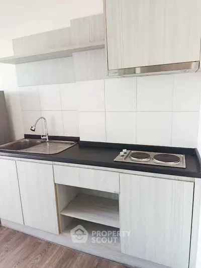 Modern kitchen with sleek cabinetry and electric stove in a stylish apartment.