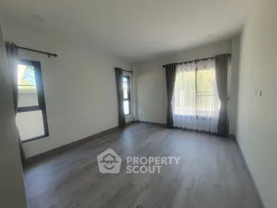 Spacious empty room with large windows and balcony access, perfect for customization.