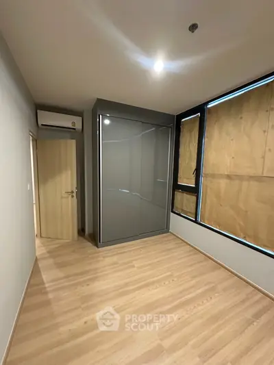Spacious bedroom with modern wardrobe and large windows