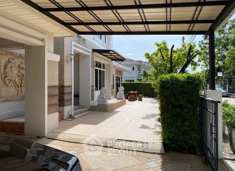 Spacious modern house entrance with covered driveway and lush greenery