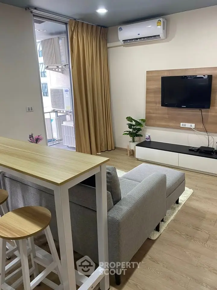 Modern living room with sleek furniture and balcony access in a stylish apartment.