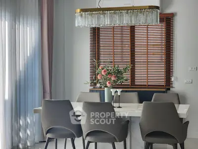 Elegant dining area with modern chairs and chandelier, perfect for stylish gatherings.
