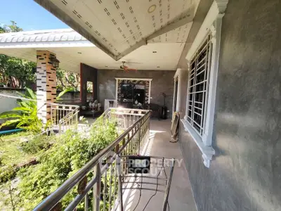 Charming outdoor patio with lush greenery and modern railing in a serene residential setting.