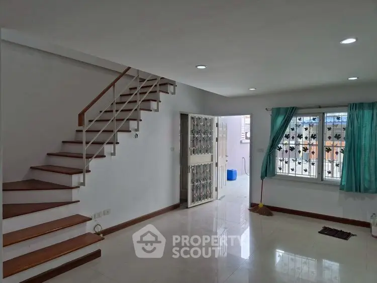 Spacious modern living room with staircase and natural light