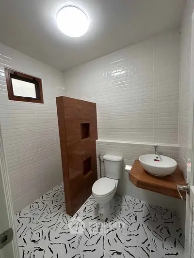 Modern bathroom with unique tile flooring and stylish wooden accents.