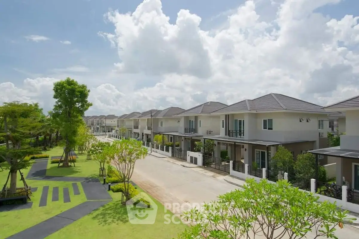 Beautiful suburban neighborhood with modern houses and lush greenery under a bright blue sky.