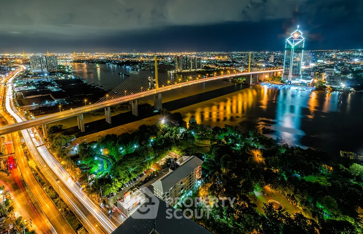 Stunning cityscape view with illuminated bridge and river at night, showcasing vibrant urban living.