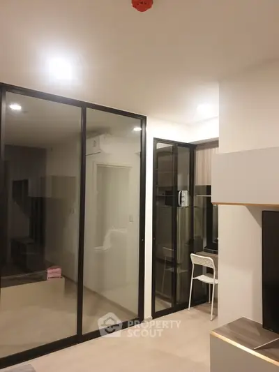 Modern living room with glass partitions and sleek furniture design