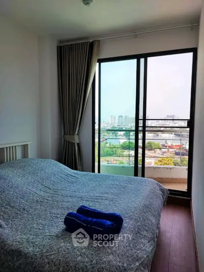 Cozy bedroom with stunning city view from large window, featuring elegant curtains and stylish bedding.
