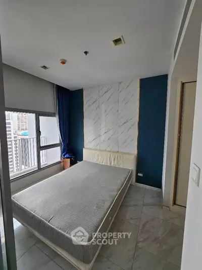 Modern bedroom with city view, featuring a large window and stylish decor in a high-rise apartment.