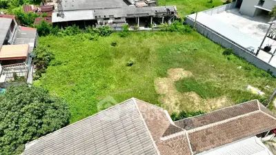 Aerial view of a spacious green plot surrounded by buildings, ideal for development opportunities.