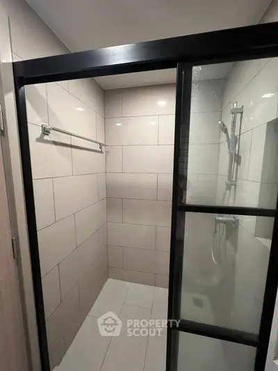 Modern bathroom with sleek glass shower enclosure and tiled walls