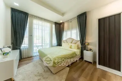 Spacious bedroom with elegant decor and large windows for natural light.