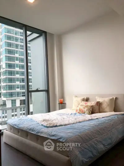 Modern bedroom with large windows and city view in luxury apartment