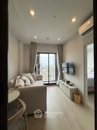 Modern living room with city view, cozy sofa, and wall-mounted TV in a stylish apartment.